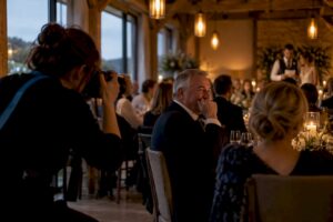Photographer capturing emotional wedding speech reaction